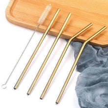 Charger l'image dans la galerie, Set of stainless steel straws in gold color with cleaning brush on wooden tray.