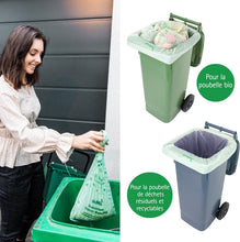 Charger l&#39;image dans la galerie, Femme utilisant un sac poubelle compostable pour déchets bio, avec deux poubelles colorées en arrière-plan.
