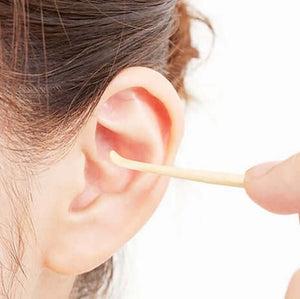 Person using eco-friendly Oriculi ear cleaner, promoting waste reduction and cost savings.